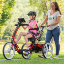 Girl riding new rifton special needs bike with helper using pushbar. 