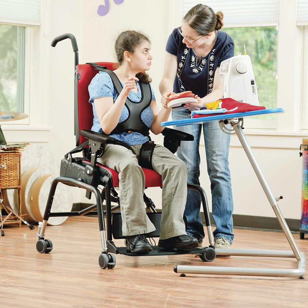 Girl in classroom with teacher in the Large Rifton Activity Chair.