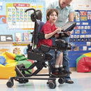 Boy tilting forward in classroom in his Medium Rifton Hi-Lo Activity Chair.