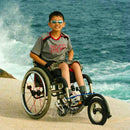 Little boy enjoying the beach in his FreeWheel Wheelchair Attachment.