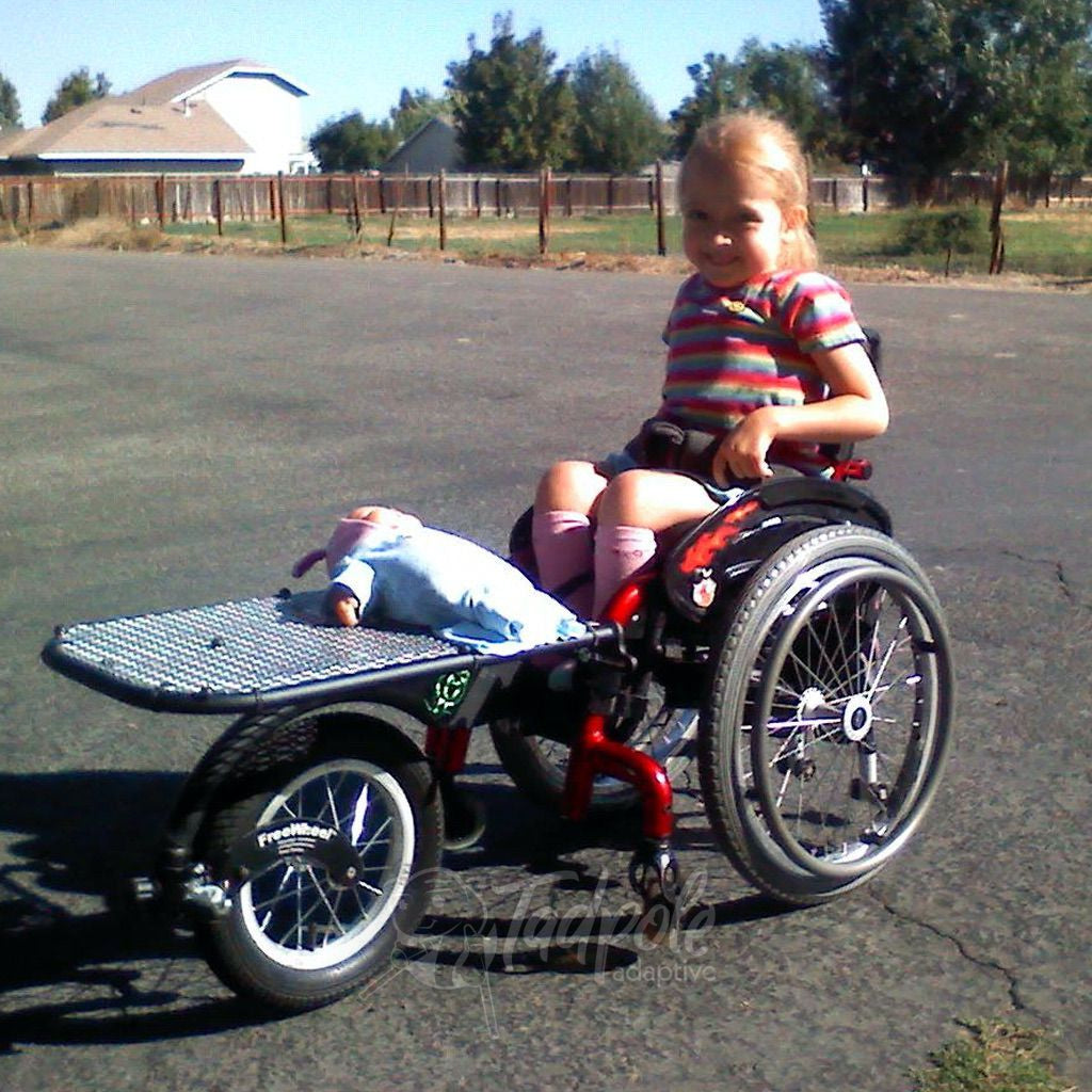Little girl in her FreeWheel Wheelchair Attachment with optional rack.