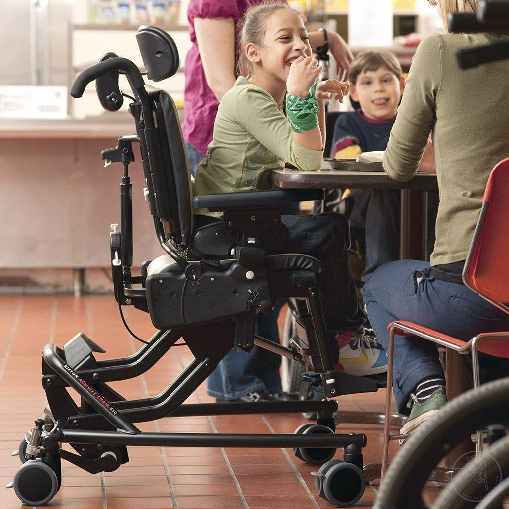 Girl in cafeteria with friends in her Medium Rifton Hi-Lo Activity Chair.