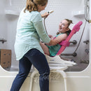 Young girl in Rifton Wave, slightly reclined on Tub Transfer Base in shower.